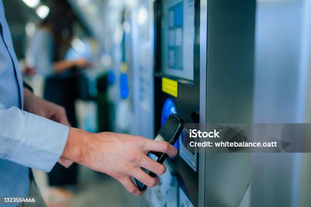 Close Up Of A Young Asian Man Using Contactless Payment Via Smartphone To Pay For Her Shopping At Selfcheckout Kiosk In Airport Stock Photo - Download Image Now