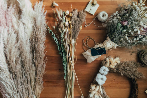 vista superior da mesa de flores e plantas secas, buquê eterno, coroa de flores e grama de pampas na mesa de madeira - dried plant - fotografias e filmes do acervo