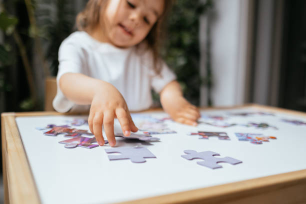 istock Little Girl Solving Jigsaw Puzzle 1323556471