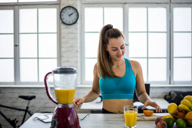 istock Young woman making detox smoothie at home 1323556974