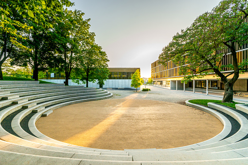 Boston, Massachusetts, USA – July 20, 2022:  Students walk by the stone steps of the grand library in Harvard Yard university campus in downtown Cambridge Massachusetts USA