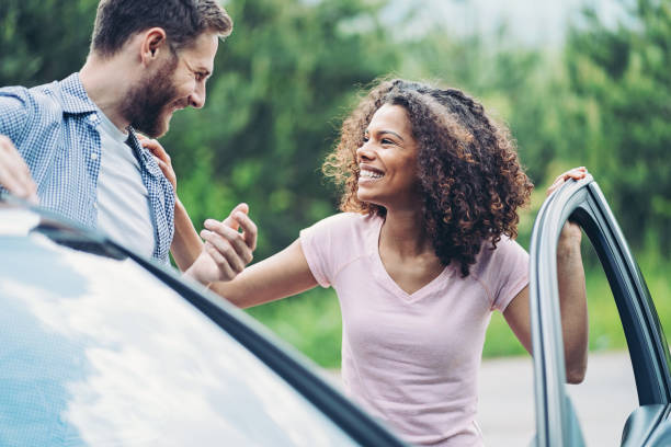 istock Smiling couple talking by a car 1323566135