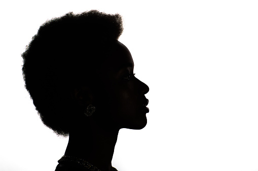 Close up profile silhouette portrait of african american woman with afro hairstyle on white studio background.