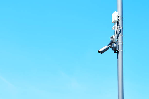 istock Security camera on a light pole on the street. CCTV surveillance security camera video equipment. Home security system concept. Safety system area control outdoor with copy space, 1323571491