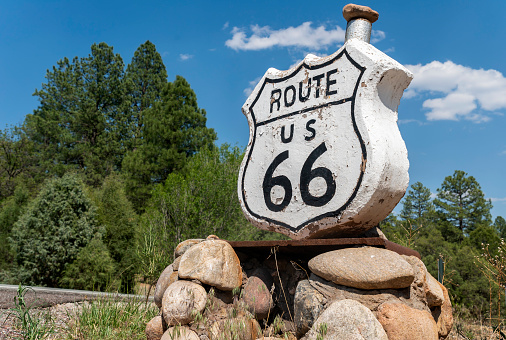 A vintage Kansas 66 highway sign painted on an asphalt highway in a rural area