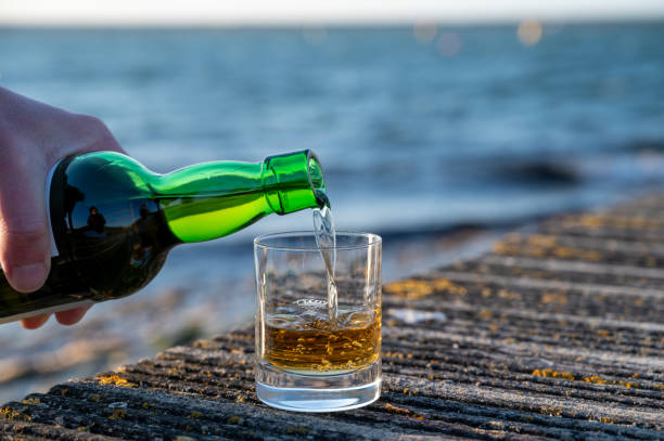 drinking single malt scotch whisky at sunset with sea, ocean or river view, private whisky tours in scotland, uk - spey scotland stockfoto's en -beelden