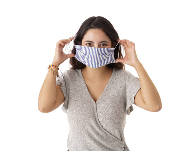 istock Young woman putting on face mask 1323577237
