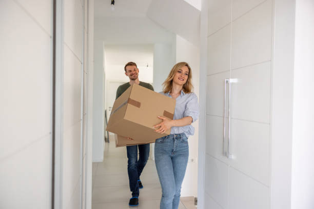 istock Mature Couple Carrying Cardboard Boxes Into New House 1323577341