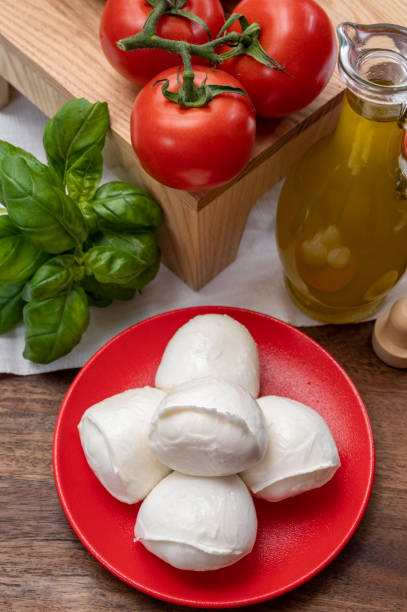 istock Cheese collection, small fresh white soft mozzarella cheese balls served with red tomatoes and fresh green basil from Italy 1323577916