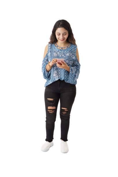 istock A young latin woman standing and using mobile phone 1323578259