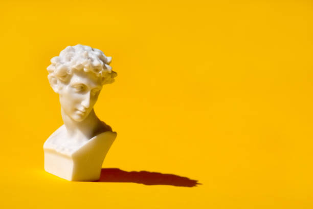 istock white statue head on yellow background. Ancient greek head sculpture. 1323578260