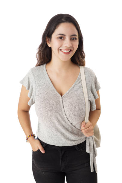 istock Young woman standing with bag and smiling at camera 1323578279
