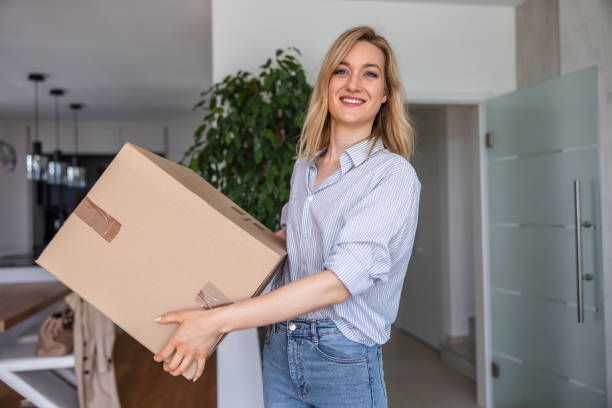 istock Heterosexual Couple Carrying Cardboard Boxes Into New Apartment 1323578302