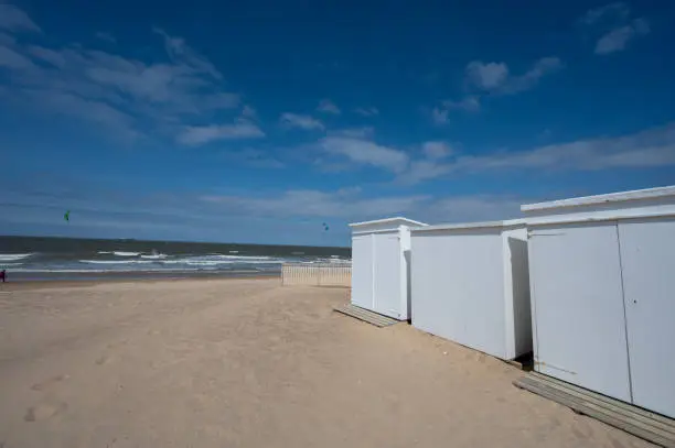 White beach huts on yellow sandy beaches in small Belgian town Knokke-Heist, luxury vacation destination, summer holidays