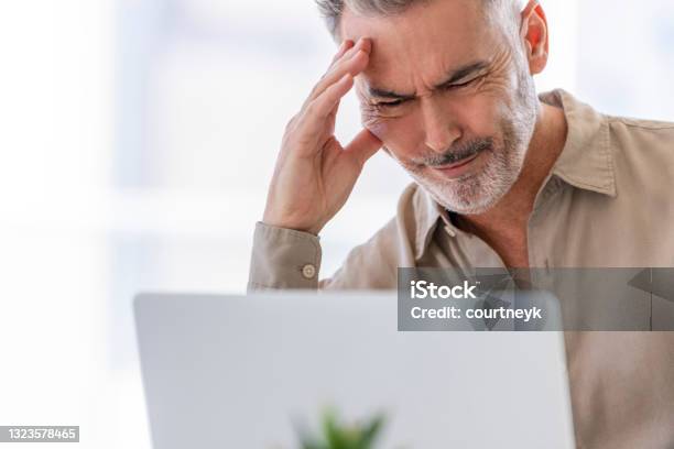 Mature Businessman Working At A Desk On A Laptop Computer Stock Photo - Download Image Now