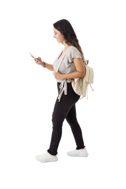istock Latin young woman walking and using mobile phone 1323579467