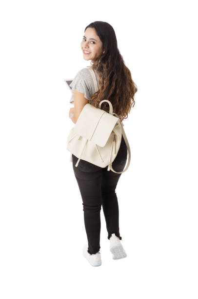 istock Back view of female student looking back and smiling 1323579469