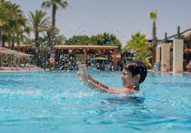 istock Boys having fun in swimming pool, holiday resort 1323581116