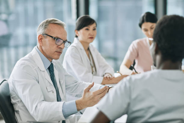 istock Mature Doctor Talking in Meeting 1323582808