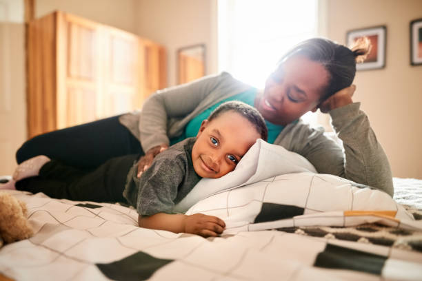 istock Mother and daughter lying on bed 1323584966