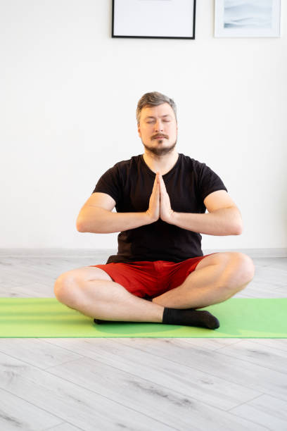 istock yoga practice calm man home training harmony 1323588235