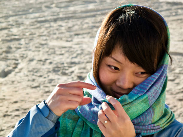 istock A young Chinese woman walking on sand beach 1323600807