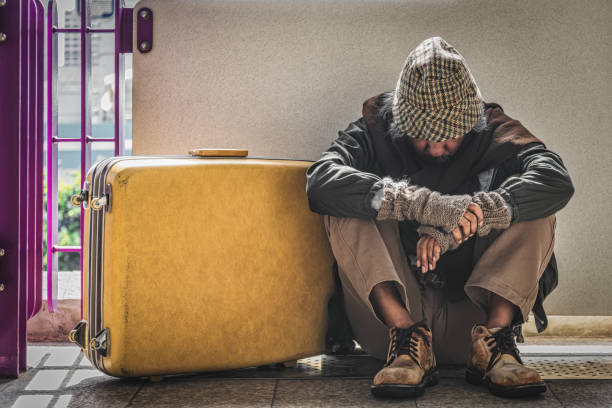 biedny bezdomny siedzący na ścieżce z bagażem czuje rozpacz i samotność. pojęcie społecznego proprem ubóstwa - tramp zdjęcia i obrazy z banku zdjęć