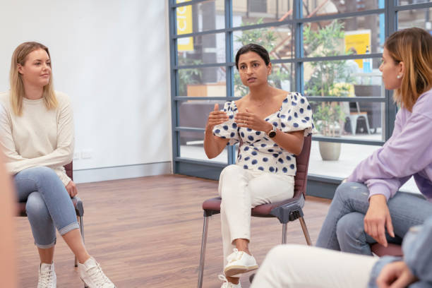 istock Young adult woman sharing life experience in group therapy 1323601657