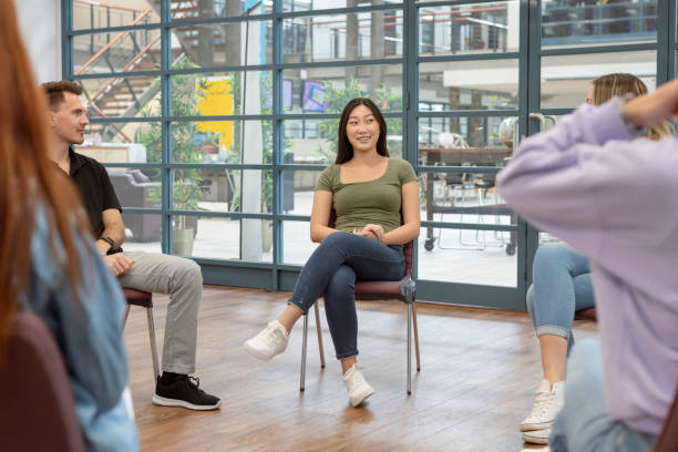 istock Hopeful woman speaking in group therapy session 1323601662