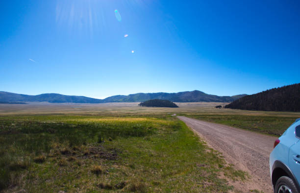 istock NM Road Trip: Car on Dirt Road in Wilderness 1323603413