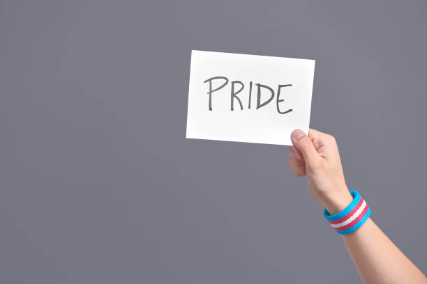 istock Hand with a transgender flag bracelet holding a paper with a message: pride 1323603479