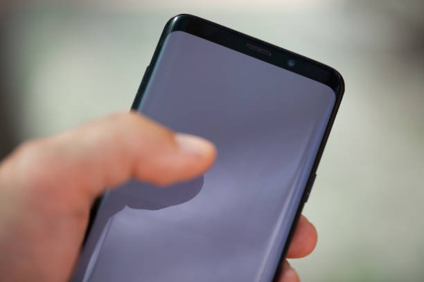 istock A businessman's hand with a modern phone 1323609054