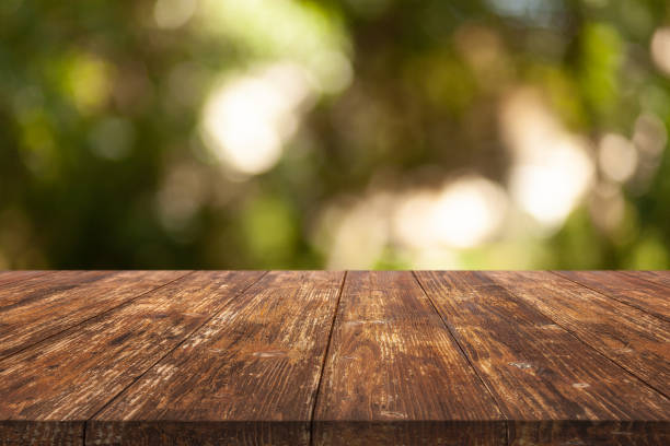 istock Wooden desk on bokeh blur abstract natural background 1323611604