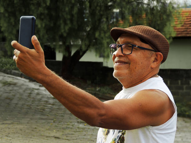 istock Beautiful image of an elderly man smiling at his smartphone while taking a selfie. 1323613621