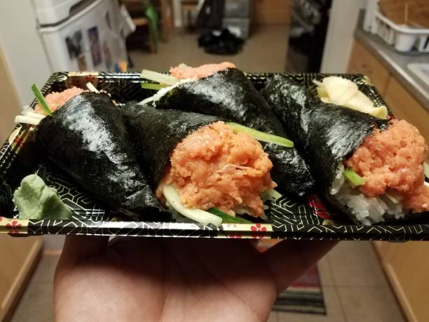 hand holding sushi spicy tuna hand rolls - handroll imagens e fotografias de stock