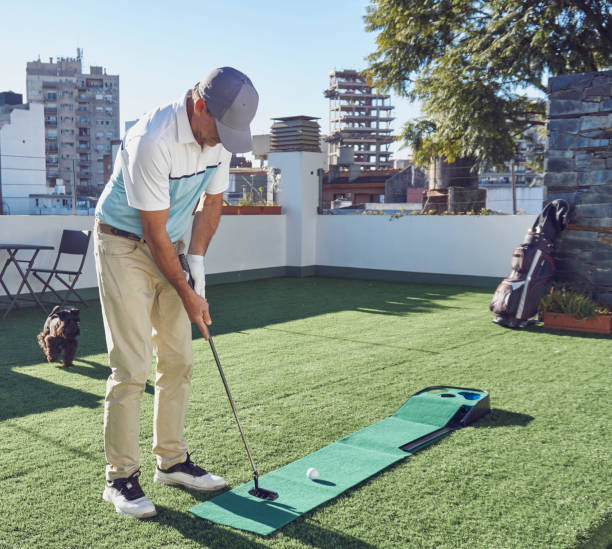 Middle-aged man playing miniature golf on the terrace