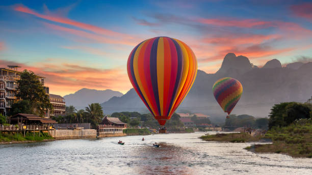 nam song river o zachodzie słońca z balonem na gorące powietrze w vang vieng, laos, piękny krajobraz na rzece nam song w vang vieng, laos. - rowboat nautical vessel river mid air zdjęcia i obrazy z banku zdjęć