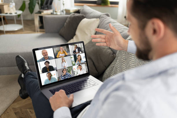 istock Young caucasian man using laptop for having virtual team meeting on video call with different people, work from home office or coworking, online meeting, briefing, brainstorming 1323619741