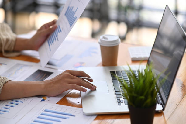 istock Businesswoman using laptop and analyzing financial data at office desk. 1323621568