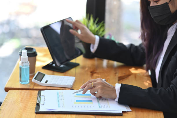 istock Businesswoman wearing protective mask working in office. 1323621608