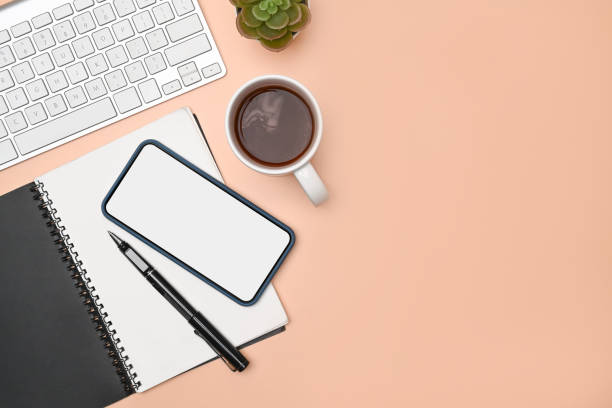 istock Minimal workspace with mobile phone, keyboard, notebook and coffee cup. 1323621658