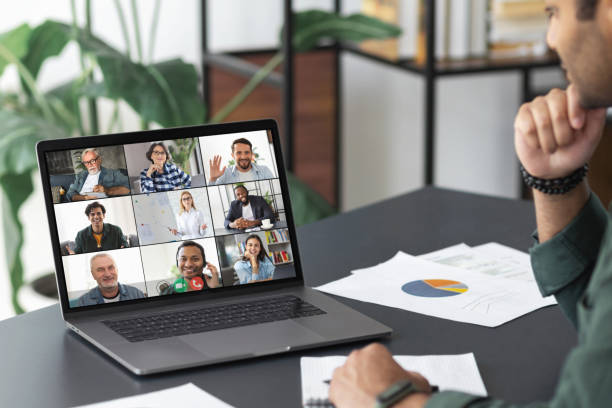 istock Meeting online concept. Young indian man using laptop for video calling with colleagues, employees in office, online meeting with many people together 1323623412