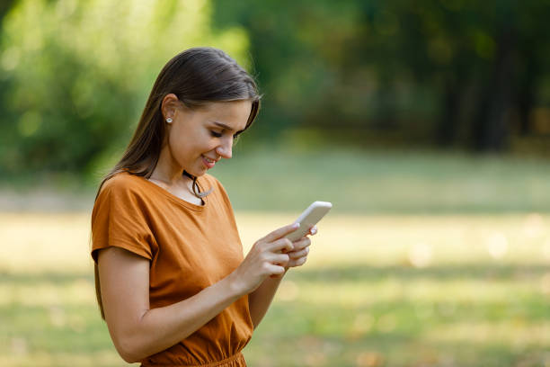 istock A Young Woman is Walking in Nature and Using a Smart Phone. 1323624301