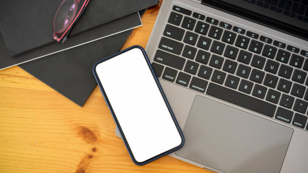 istock Top view of smartphone with mock-up screen on laptop on workspace 1323625998
