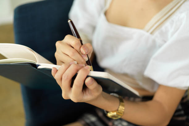 istock Female handwriting on schedule book while working in meeting room 1323625999