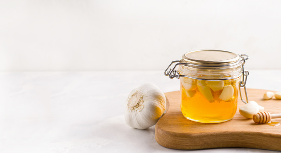 Fermented honey with garlic on a light background. Copy space. Banner