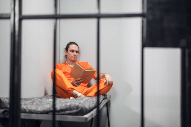 istock A young inmate with a tattooed face is being remotely trained in a cell. Reads a textbook sitting on a bunk 1323629642
