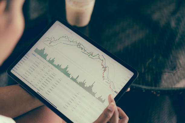 istock Business woman hand holding digital tablet computer with graph of Binary option for trading platform, setective focus 1323629784