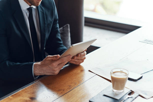istock Close up of young businessman in full suit using digital tablet 1323632136