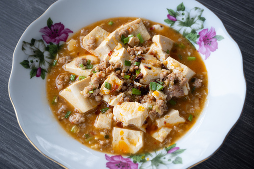 Mapo tofu is a popular Chinese dish from Sichuan province. It consists of tofu set in a spicy sauce, typically a thin, oily, and bright red suspension, based on douban (fermented broad bean and chili paste) and douchi (fermented black beans), along with minced meat.